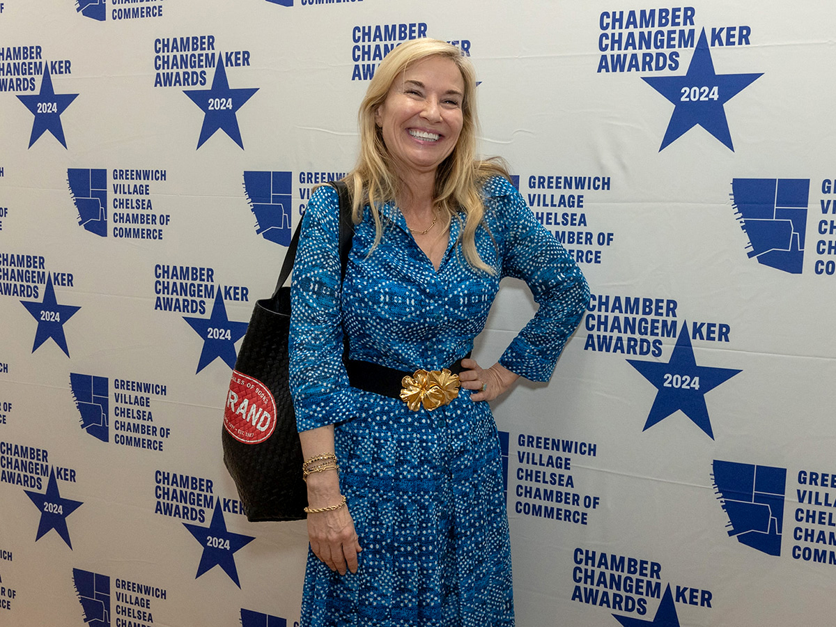 Award recipient in front of step and repeat banner