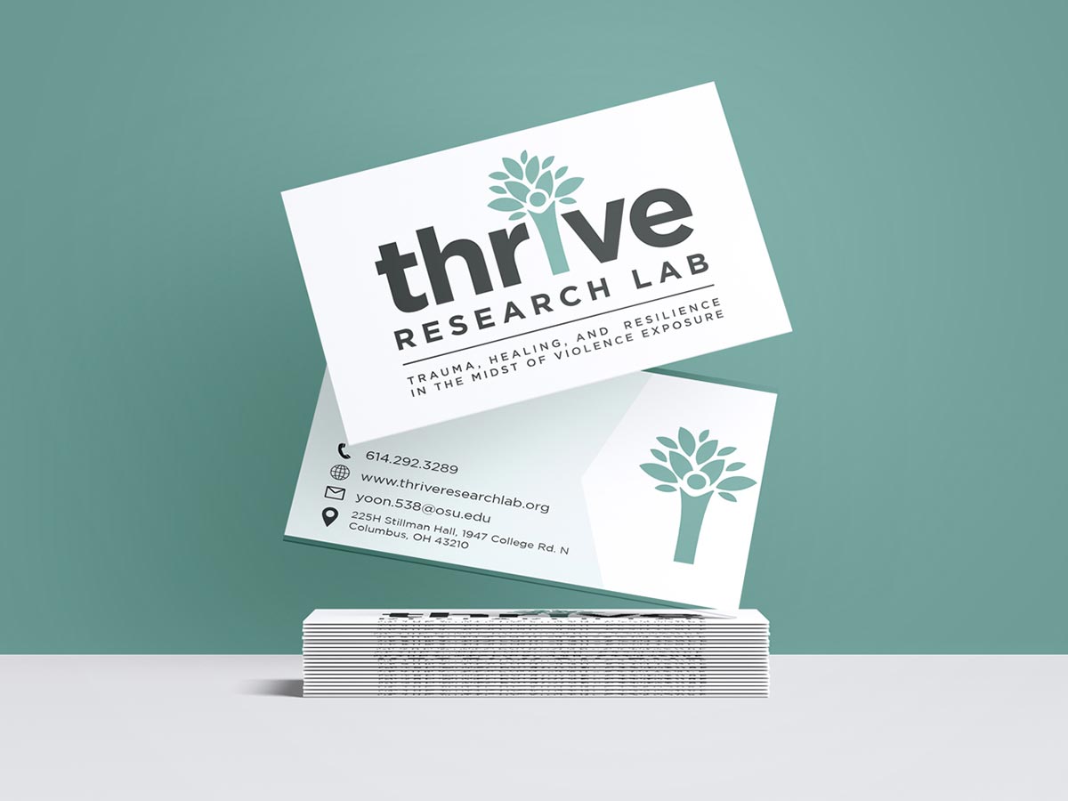 Stack of business cards featuring the Thrive Research Lab logo and contact information on a teal background.